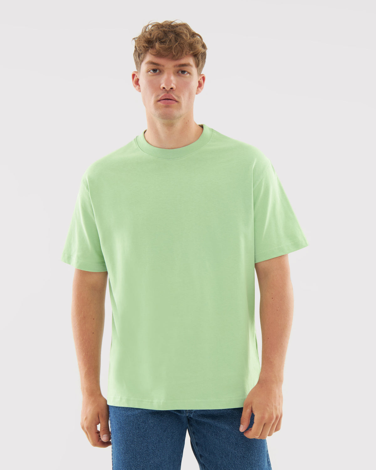 Männliches Modell trägt oversized T-Shirt 'Sammy' in Salbeigrün mit rundem Hals