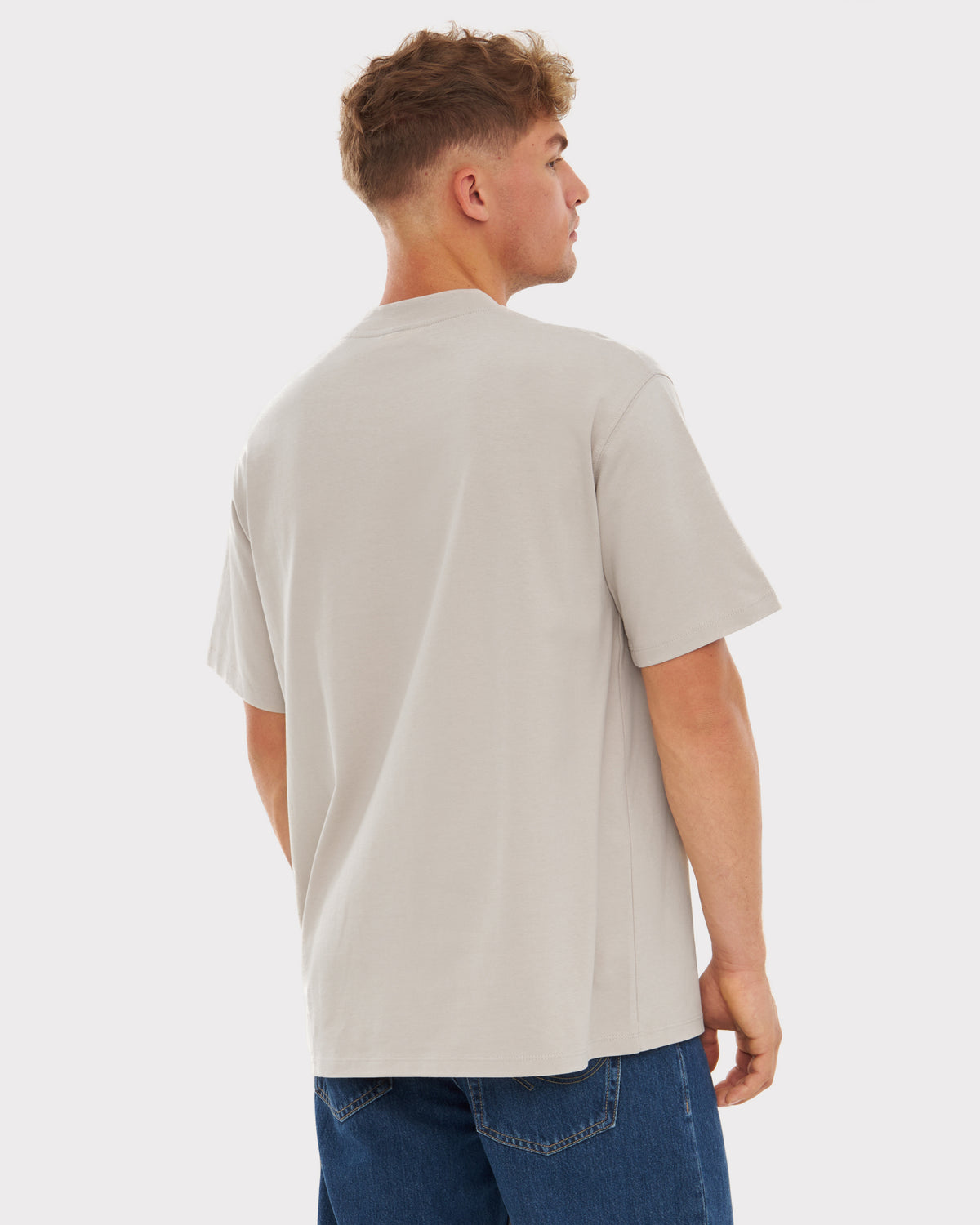 Rückansicht eines Mannes in beige oversized T-Shirt 'Sammy' von Johnny Urban und blauer Jeans