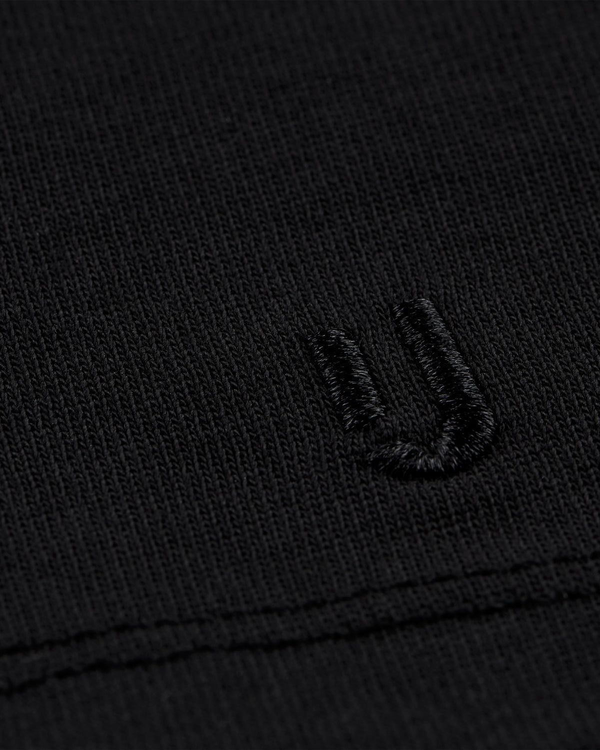 schwarzes Stoffdetail mit gesticktem 'JU'-Logo auf T-Shirt Sammy