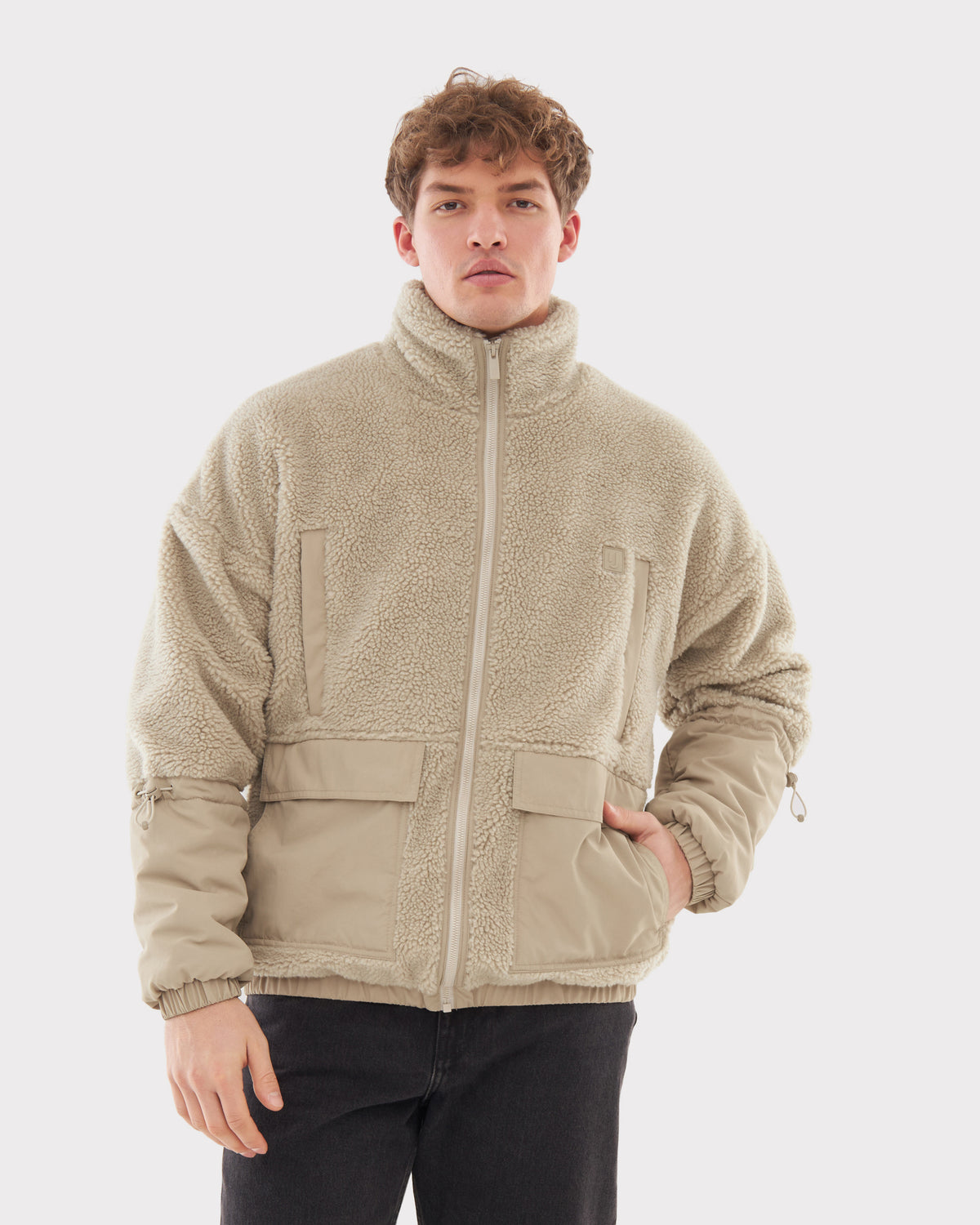 Mann trägt beige Teddy Fleecejacke 'Carson' mit hohem Kragen und Reißverschluss