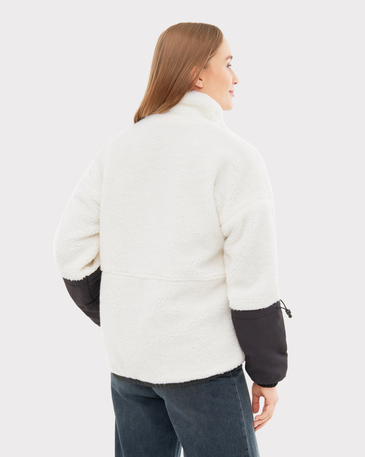 Frau trägt Teddy Fleecejacke 'Carson' in Creme mit schwarzen Ärmeln, Rückansicht