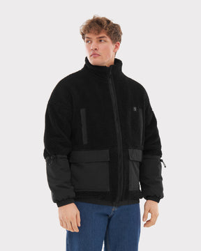 Mann trägt schwarze Johnny Urban Teddy Fleecejacke 'Carson' mit grober Textur, Reißverschluss und Stoffeinsätzen an Ärmeln und Taschen