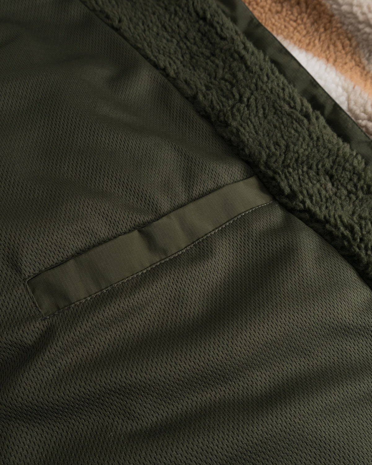 Detailaufnahme der dunkelolivgrünen Innen- und Fleeceaußenseite der Teddy Fleecejacke 'Carson'