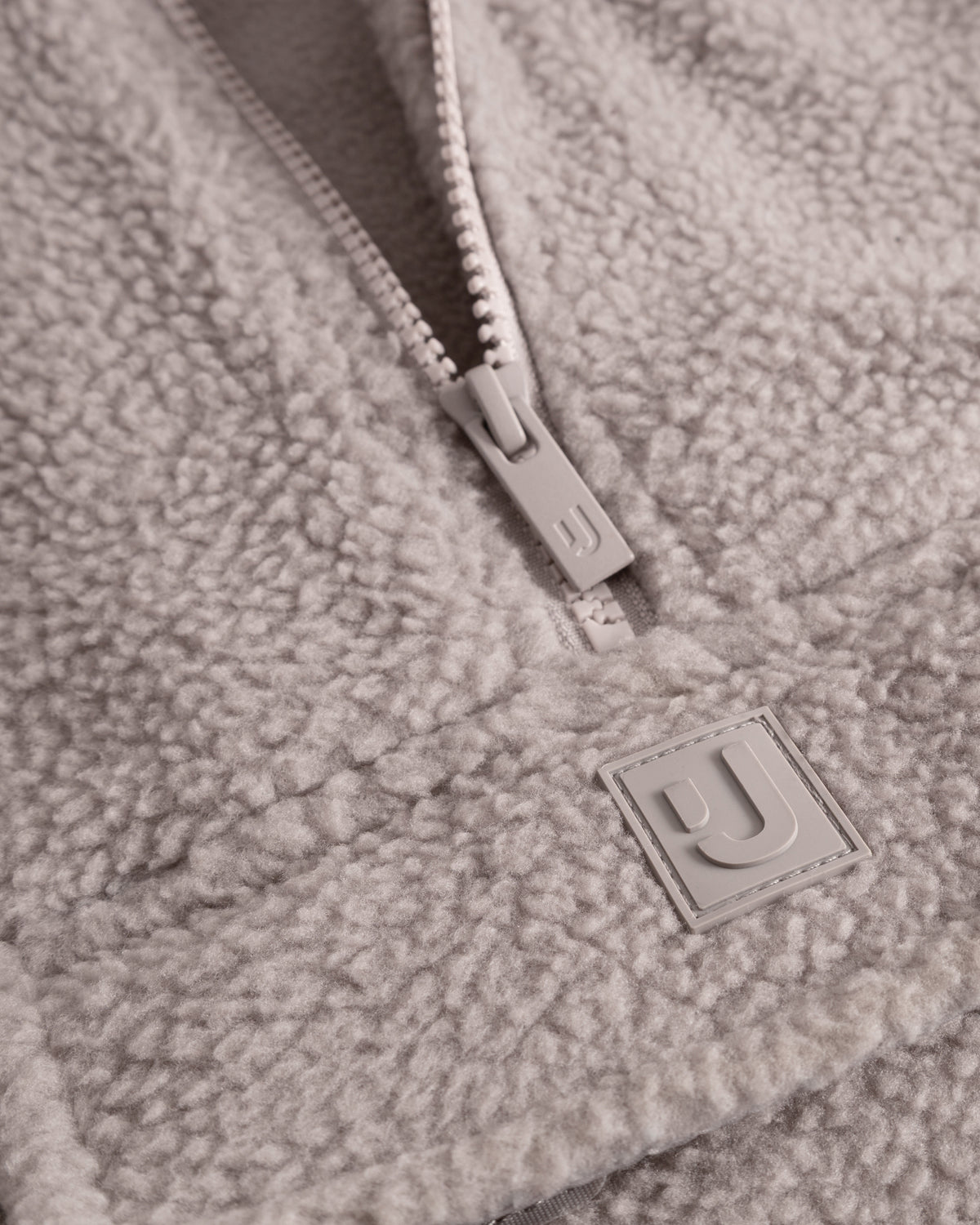 Unser hochwertiges Logo-Badge auf dem Fleecepullover Ruben in Beige. 