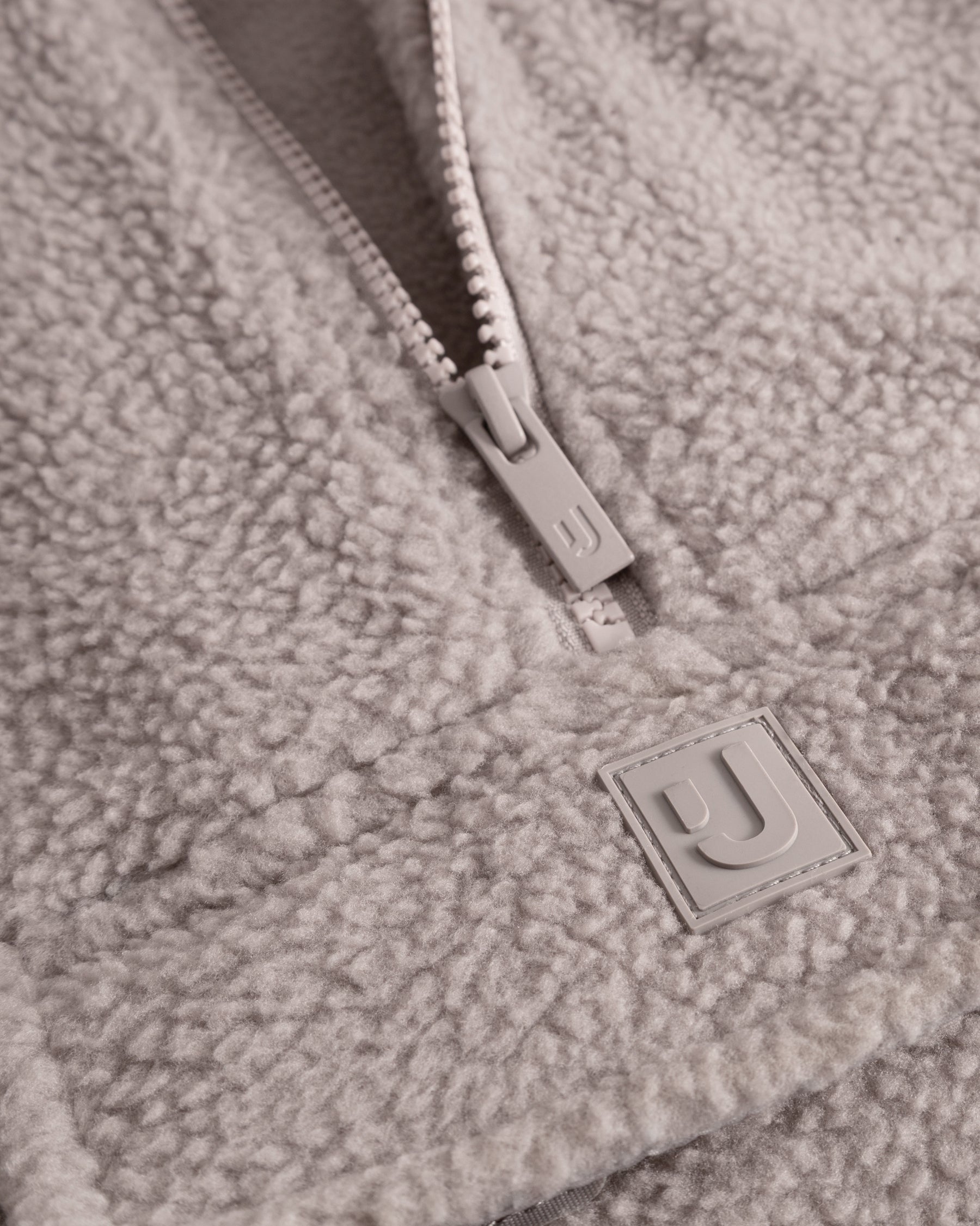 Unser hochwertiges Logo-Badge auf dem Fleecepullover Ruben in Beige. 