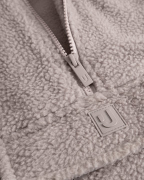 Unser hochwertiges Logo-Badge auf dem Fleecepullover Ruben in Beige. 