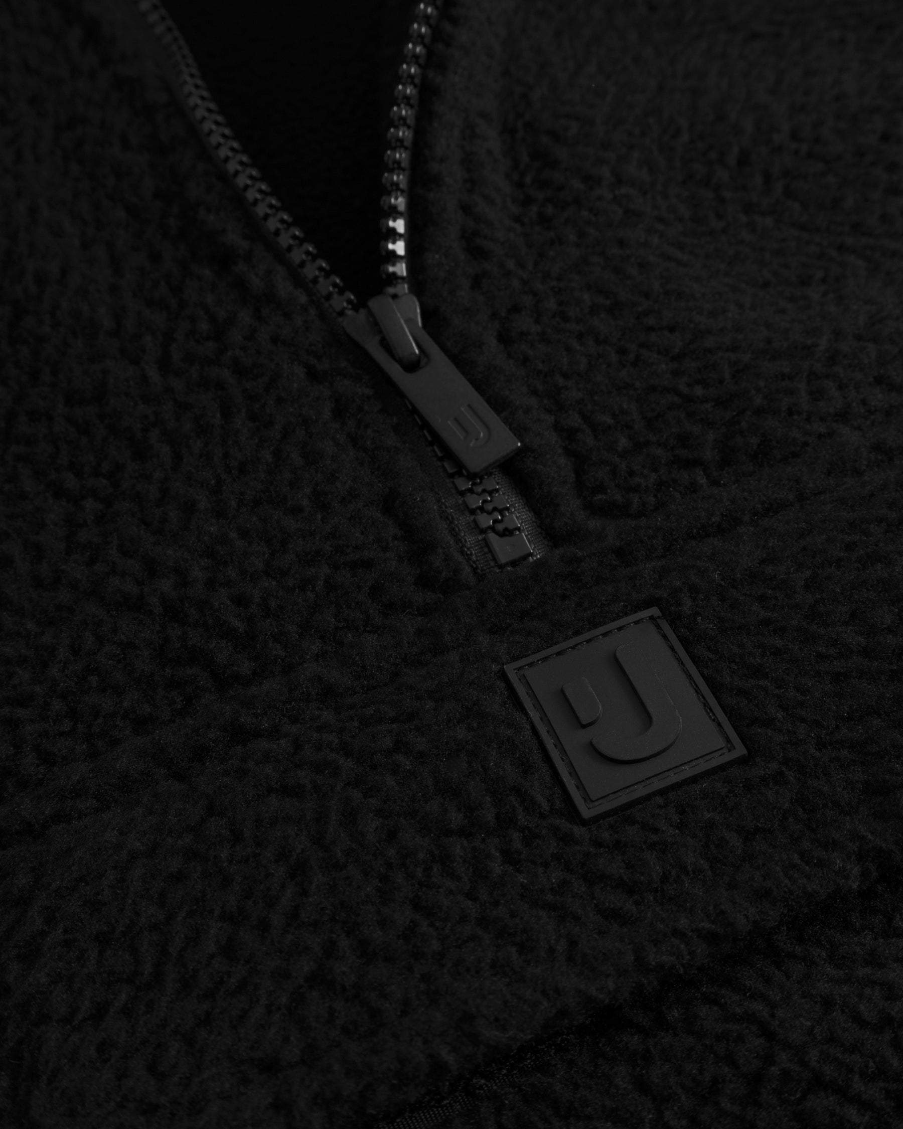 Unser hochwertiges Logo-Badge auf dem Fleecepullover Ruben in Schwarz. 