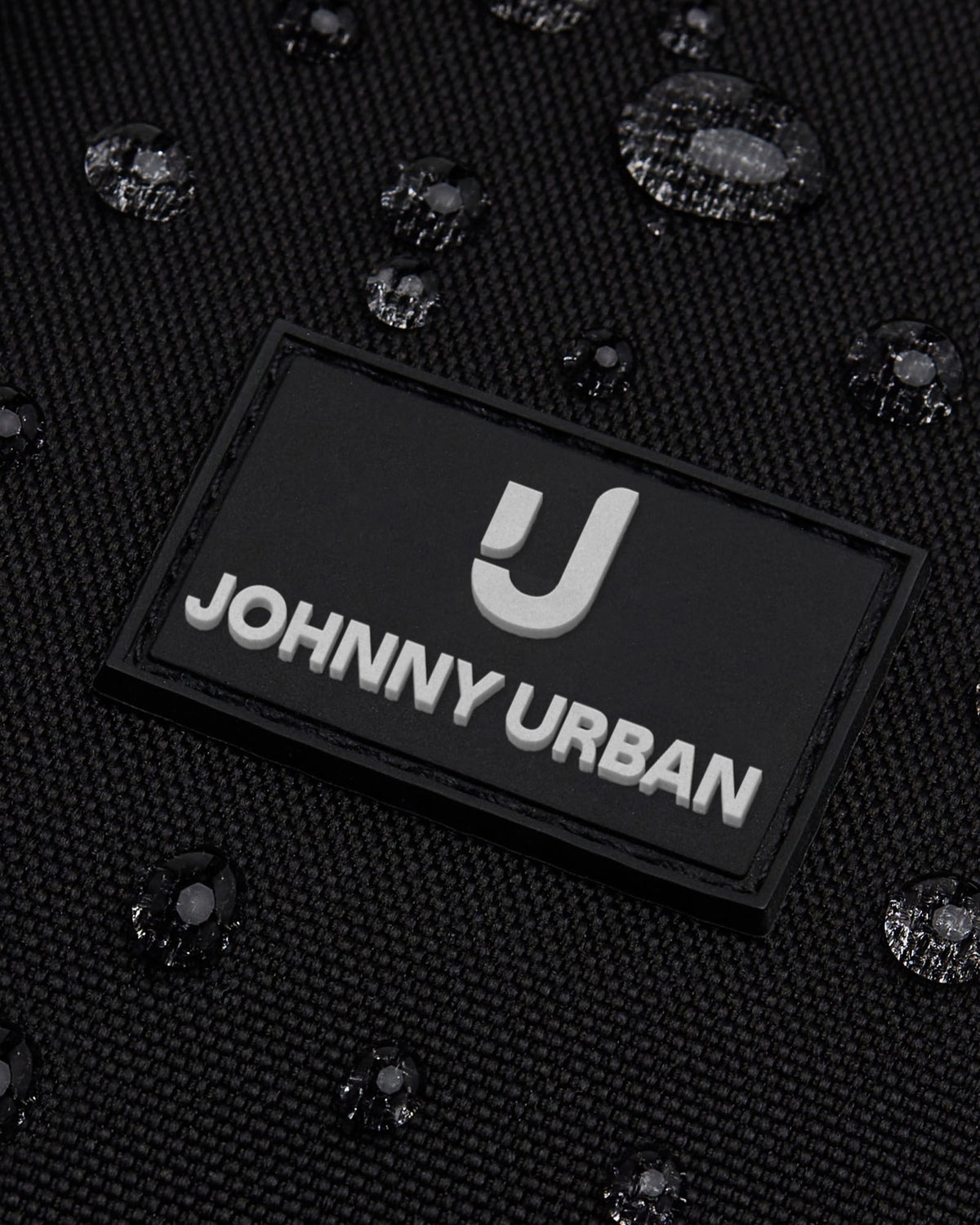 Nahaufnahme des wasserdichten Front Packs ‚Arthur‘ von Johnny Urban mit Logo und Wassertröpfchen