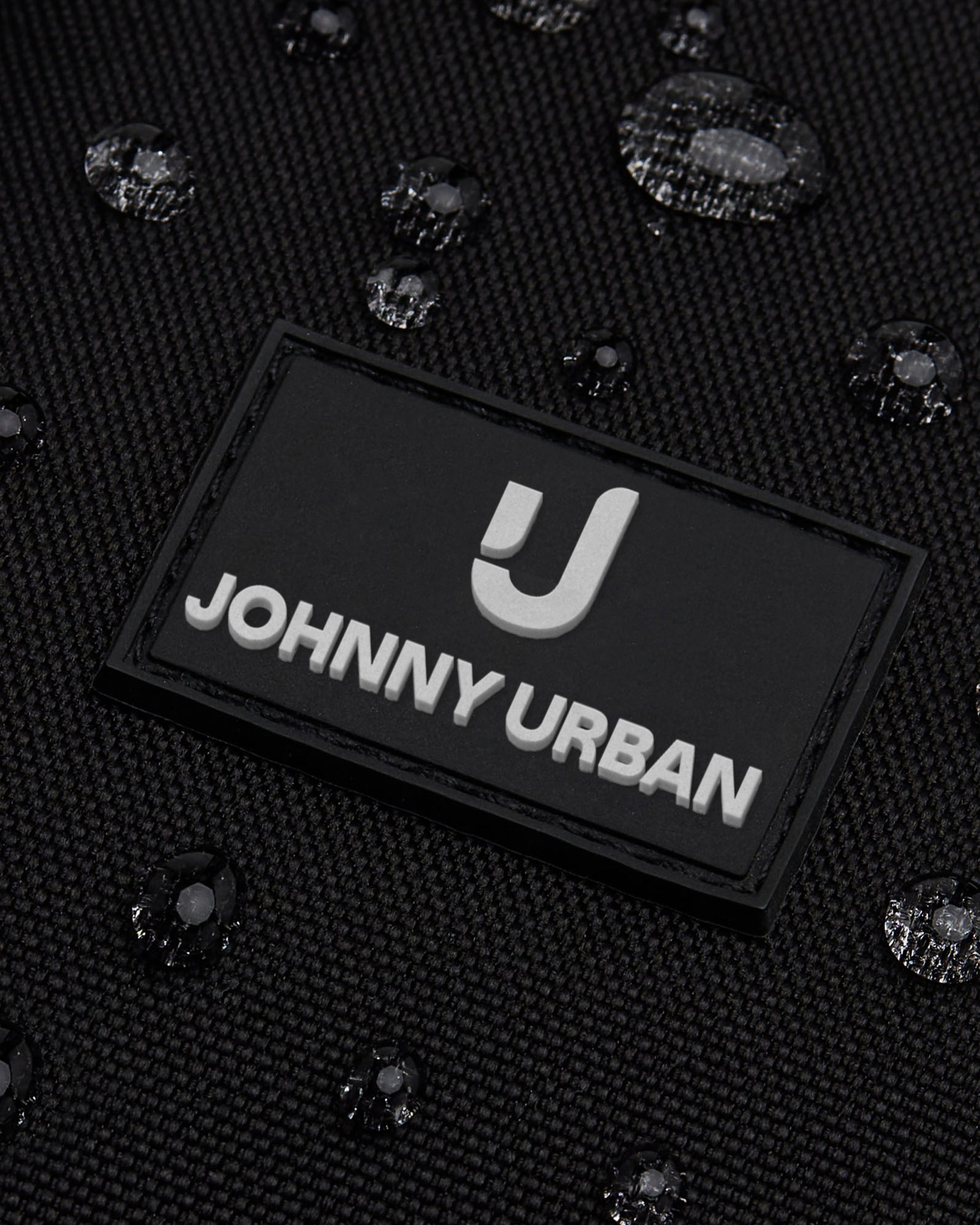 Nahaufnahme des wasserdichten Front Packs ‚Arthur‘ von Johnny Urban mit Logo und Wassertröpfchen
