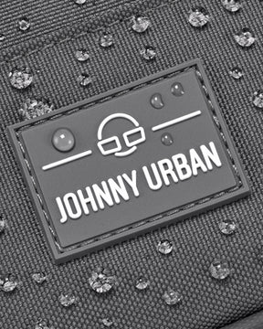 Nahaufnahme des Johnny Urban Logos auf wasserabweisendem Front Pack 'Arthur' mit Wassertröpfchen