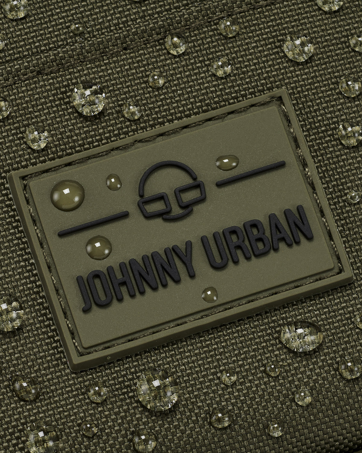 Wasserabweisender Front Pack 'Arthur' von Johnny Urban mit aufgenähtem Logo und Wassertropfen auf grünem Stoff