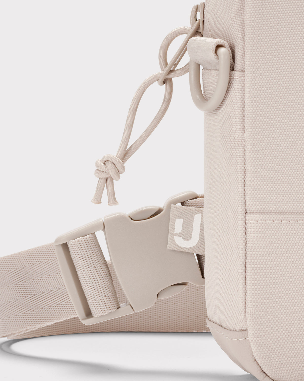 Beige Front Pack 'Arthur' von Johnny Urban, gezeigt ist der verstellbare Gurt mit Steckverschluss und Kordelzug