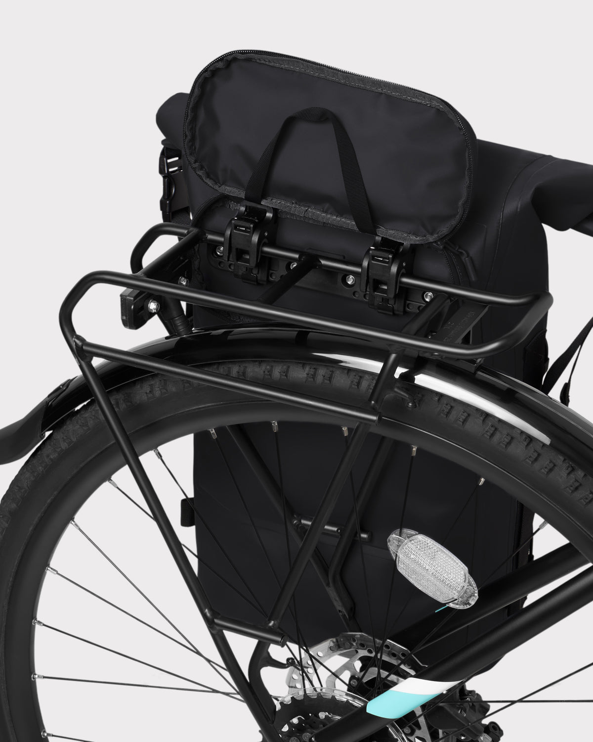 Schwarzer wasserdichter Rolltop Rucksack 'Myles' an Fahrradgepäckträger befestigt