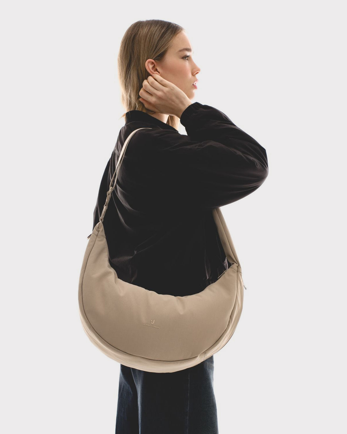 Unser weibliches Model präsentiert sich hier mit der Half-Moon-Bag "Lou Large" in beige. 