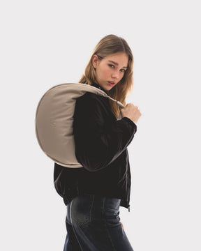 Unser weibliches Model präsentiert sich hier mit der Half-Moon-Bag "Lou Large" in beige. 