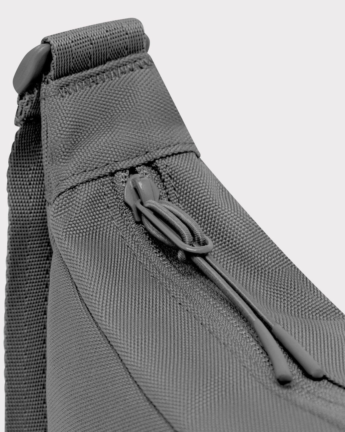 Nahaufnahme des Reißverschlusses und Trägers der halbrunden Tasche 'Ally Small' von Johnny Urban in grauem Textil