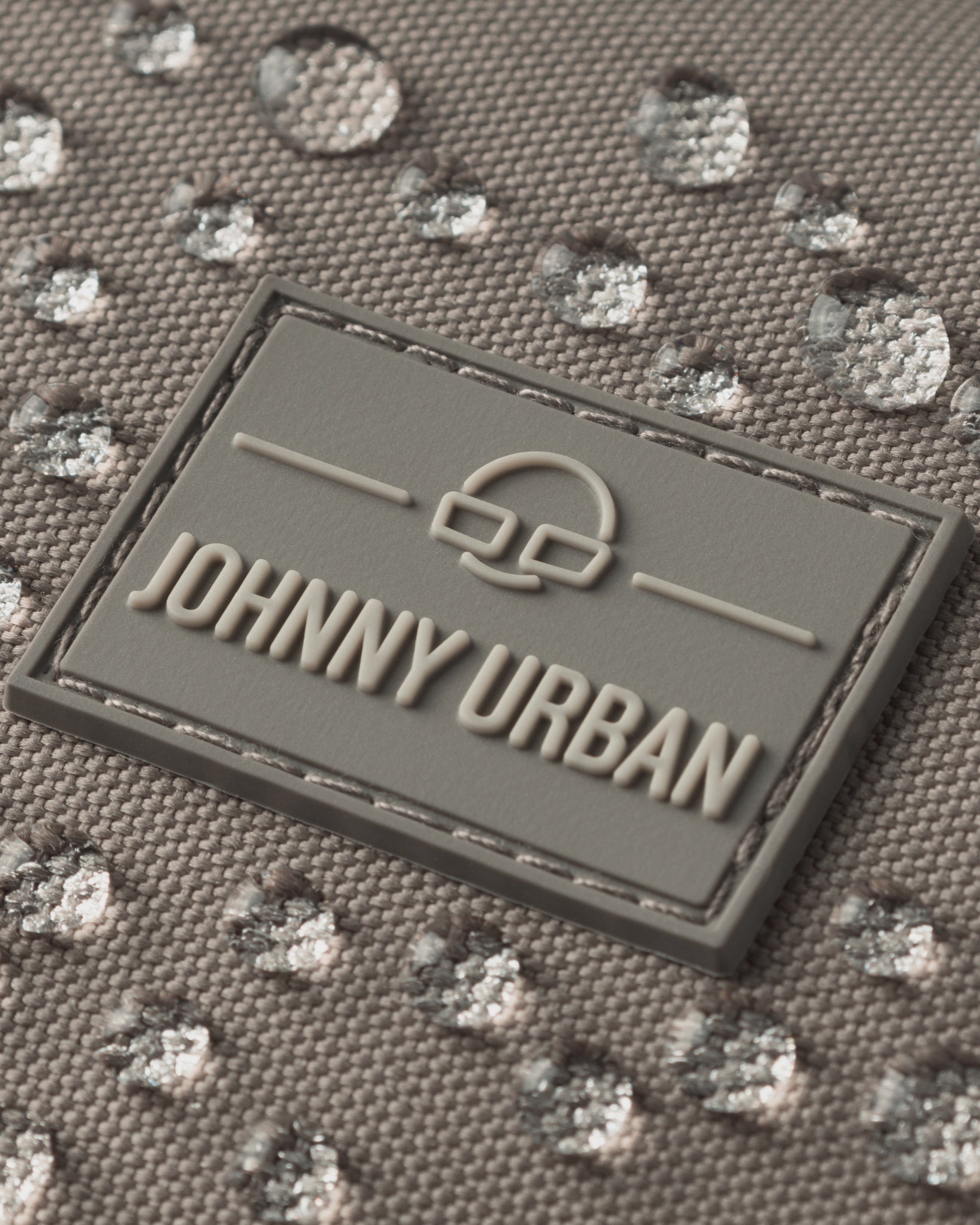 Nahe Aufnahme des wasserabweisenden Half Moon Bags 'Ally Small' in desert-grau mit Johnny Urban Logo.