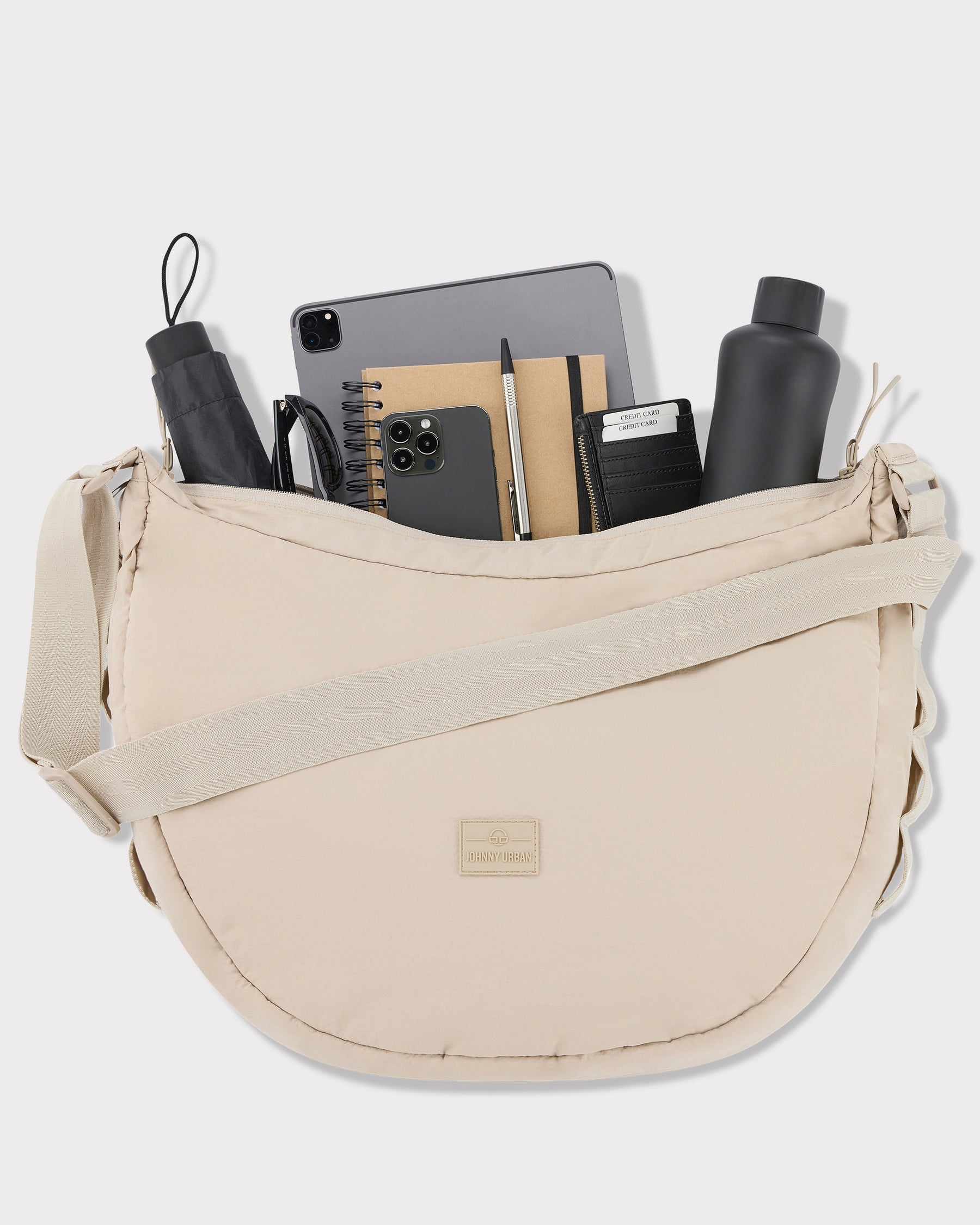Beige Half Moon Bag 'Kaia XL' von Johnny Urban mit Tablet, Smartphone, Notizbuch, Stift, Geldbörse, Wasserflasche und Regenschirm