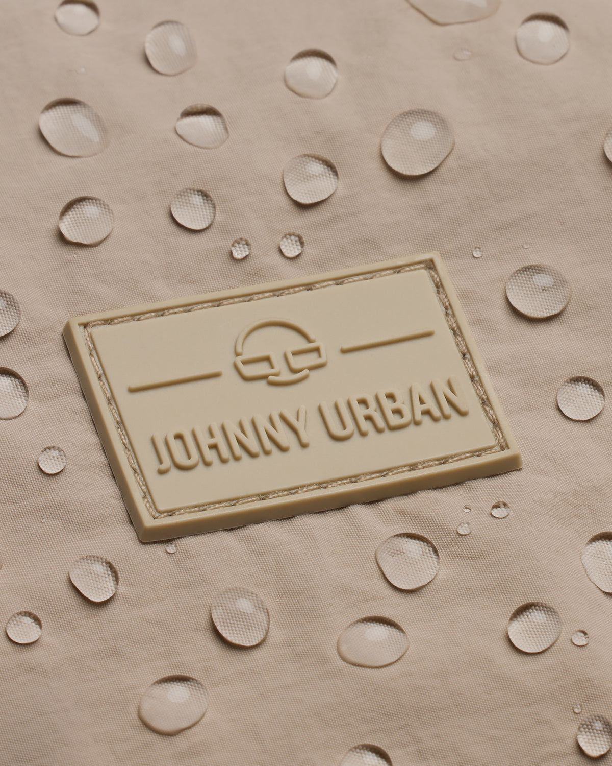 Wasserabweisendes beiges Material mit Johnny Urban Logo und Wassertröpfchen