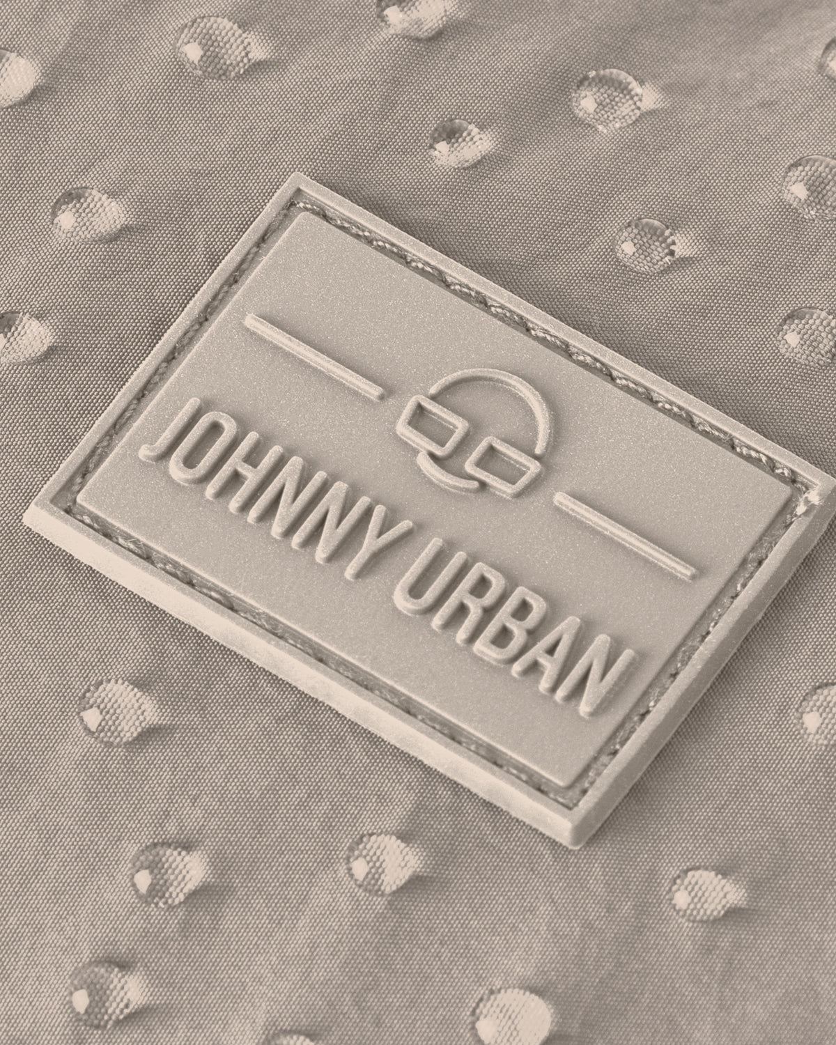 Johnny Urban Markenlabel auf wasserabweisendem beige Stoff mit Wassertropfen