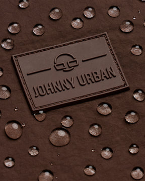 Johhny Urban Logo auf braunem, wasserabweisendem Stoff mit Wassertropfen