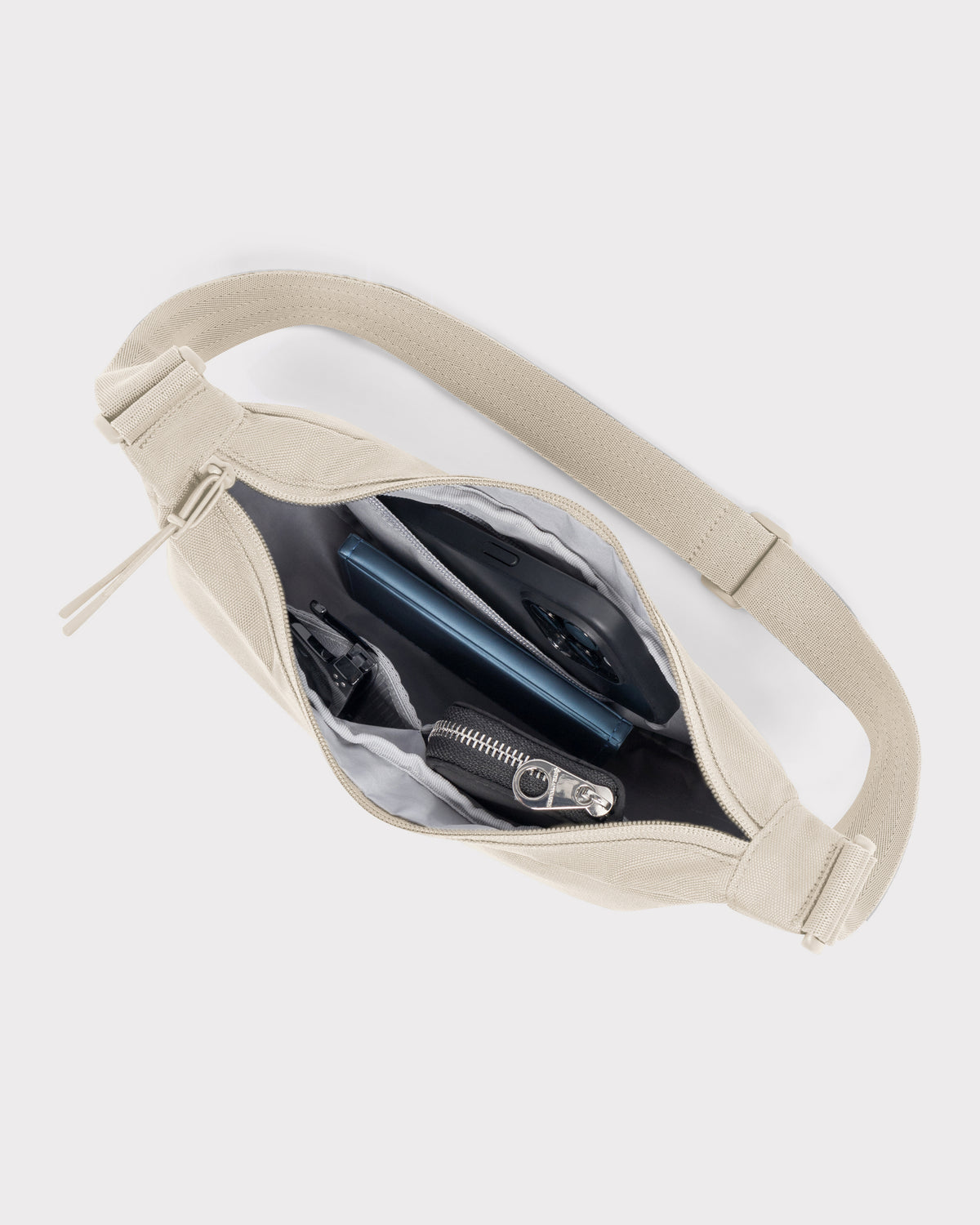 Sandfarbene Half Moon Bag 'Ally Small' mit geöffnetem Reißverschluss, Ansicht Innenfächer mit Schlüssel, Handy, Geldbörse
