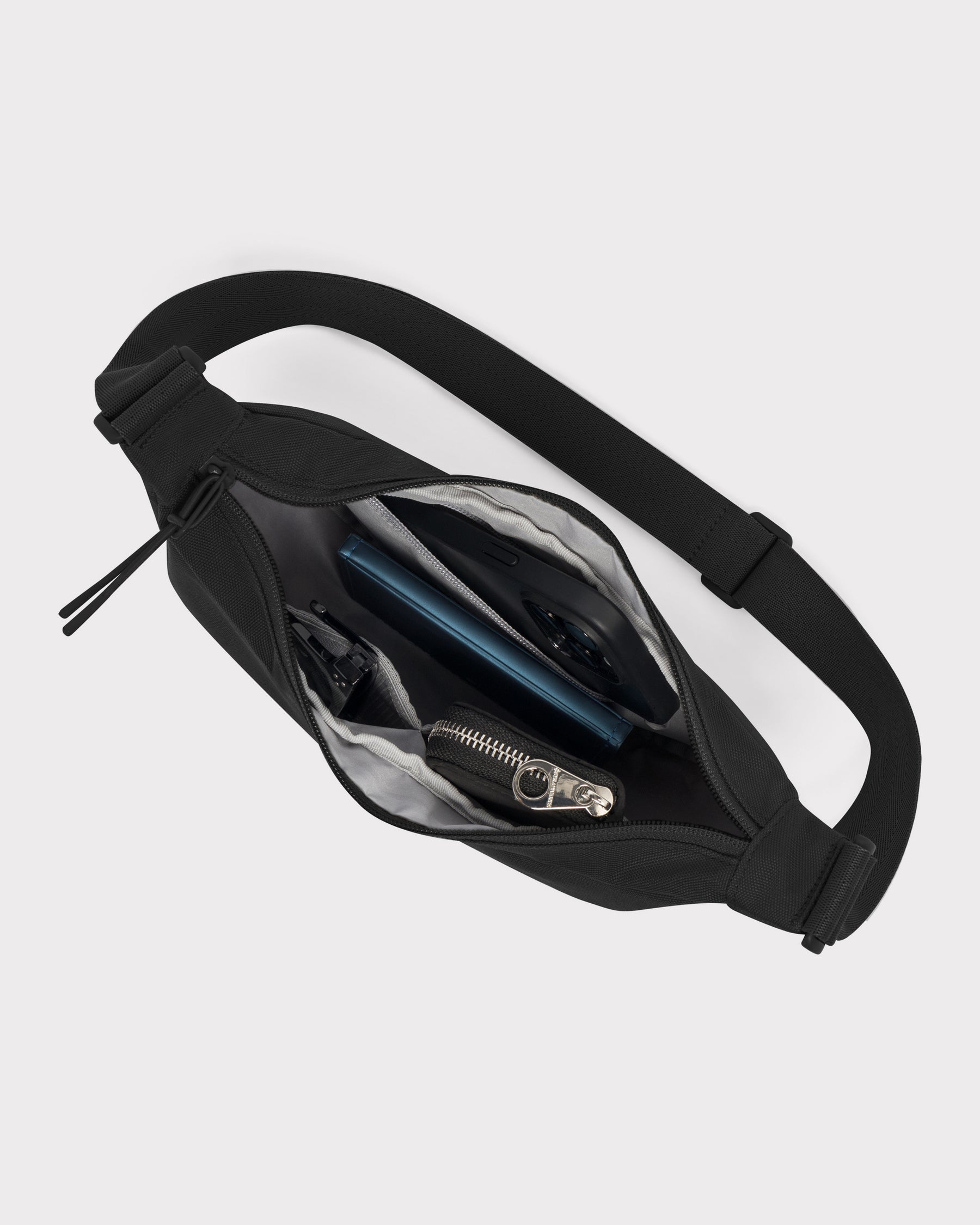 Half Moon Bag Ally Small in Schwarz mit verstellbarem Gurt und mehreren Fächern, geöffnet mit sichtbarem Inhalt