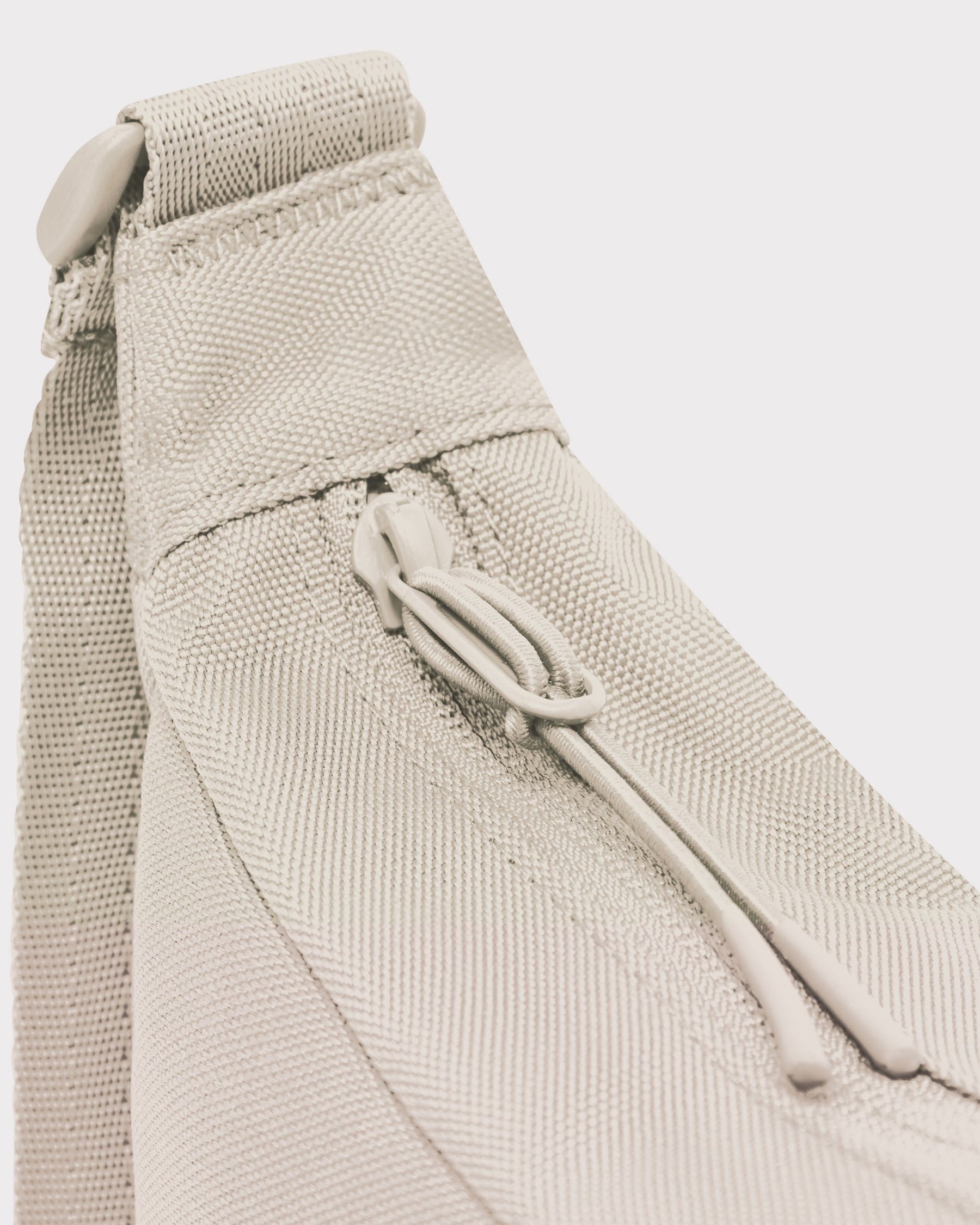 Detailansicht des Reißverschlusses und der Trageschlaufe der sandfarbenen Half Moon Bag 'Ally Small'