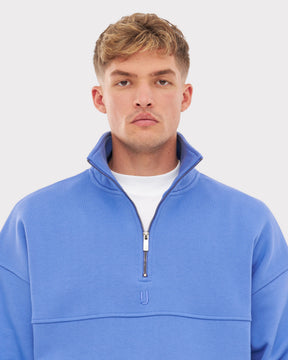 Mann trägt blauen Half Zip Sweatshirt 'Cooper' mit aufrechtem Kragen und silbernem Reißverschluss
