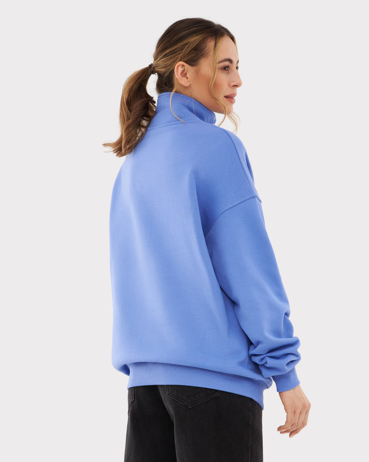 Frau trägt Half Zip Sweatshirt 'Cooper' in blau-lila, Seitenansicht, schwarzer Jeans