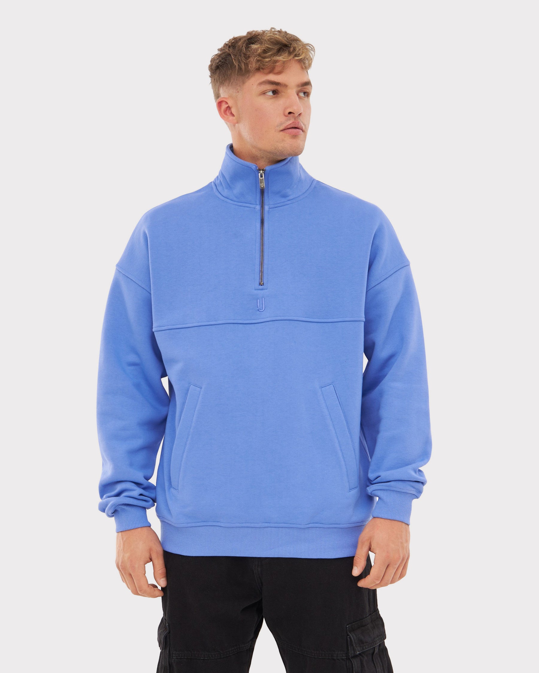 Mann trägt blauen Johnny Urban Half Zip Pullover 'Cooper' mit hohem Kragen und Reißverschluss