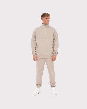 Mann trägt beigefarbenen Half Zip Sweatshirt 'Cooper' mit Reißverschluss und passende Jogginghose