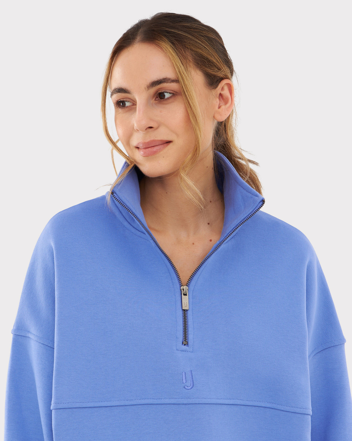 Frau trägt Half Zip Sweatshirt 'Cooper' von Johnny Urban in blau-lila mit hohem Kragen und kurzem Reißverschluss