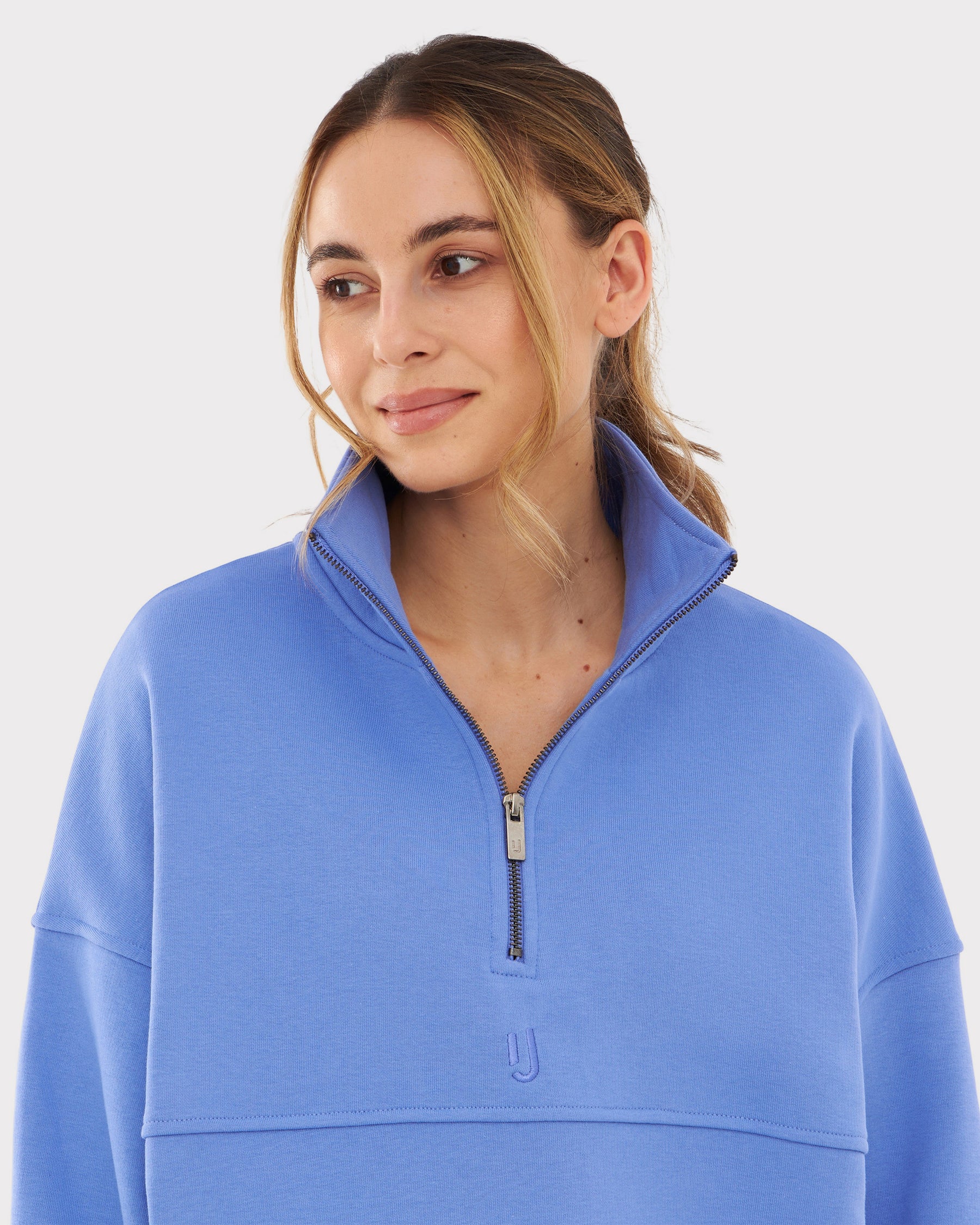 Frau trägt Half Zip Sweatshirt 'Cooper' von Johnny Urban in blau-lila mit hohem Kragen und kurzem Reißverschluss