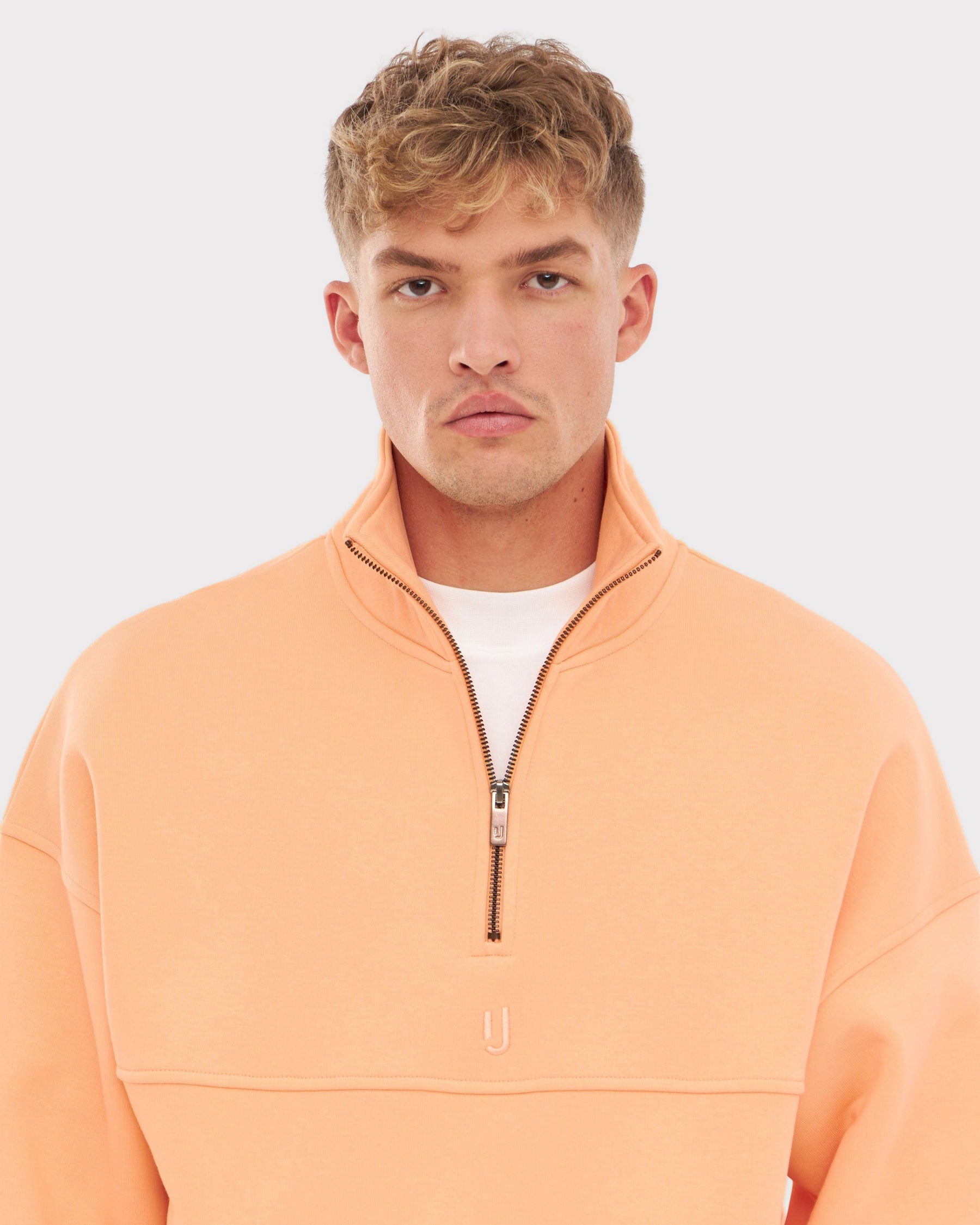 Mann trägt pfirsichfarbenes Half-Zip Sweatshirt 'Cooper' von Johnny Urban mit Stehkragen und halbem Reißverschluss