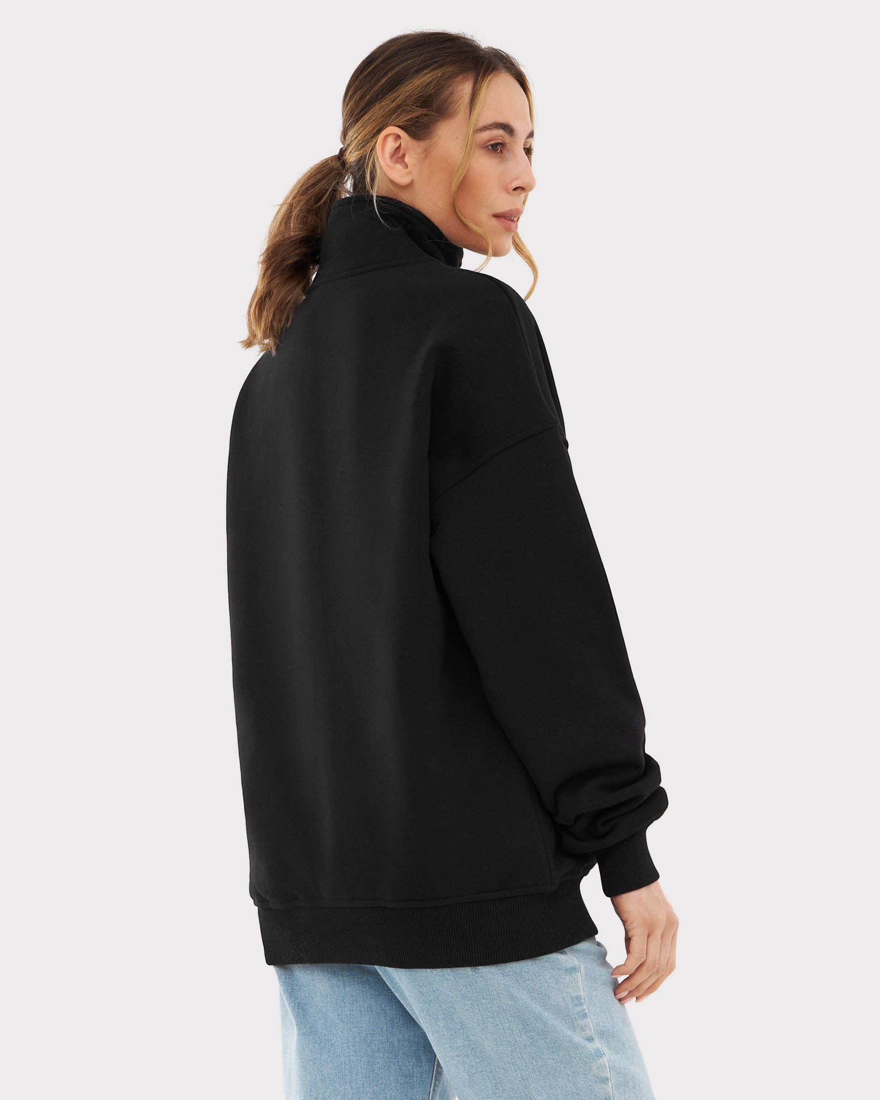 Frau mit halblangem Pferdeschwanz trägt schwarzen Oversize-Halbreißverschluss-Sweatshirt 'Cooper' von Johnny Urban