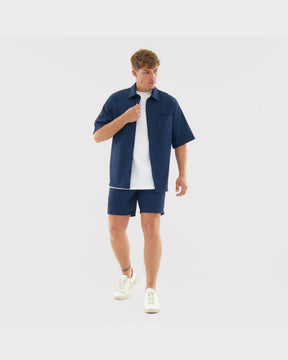 Mann trägt lässiges navyblaues Hemd mit kurzer Hose und weißem T-Shirt Set 'Mason'
