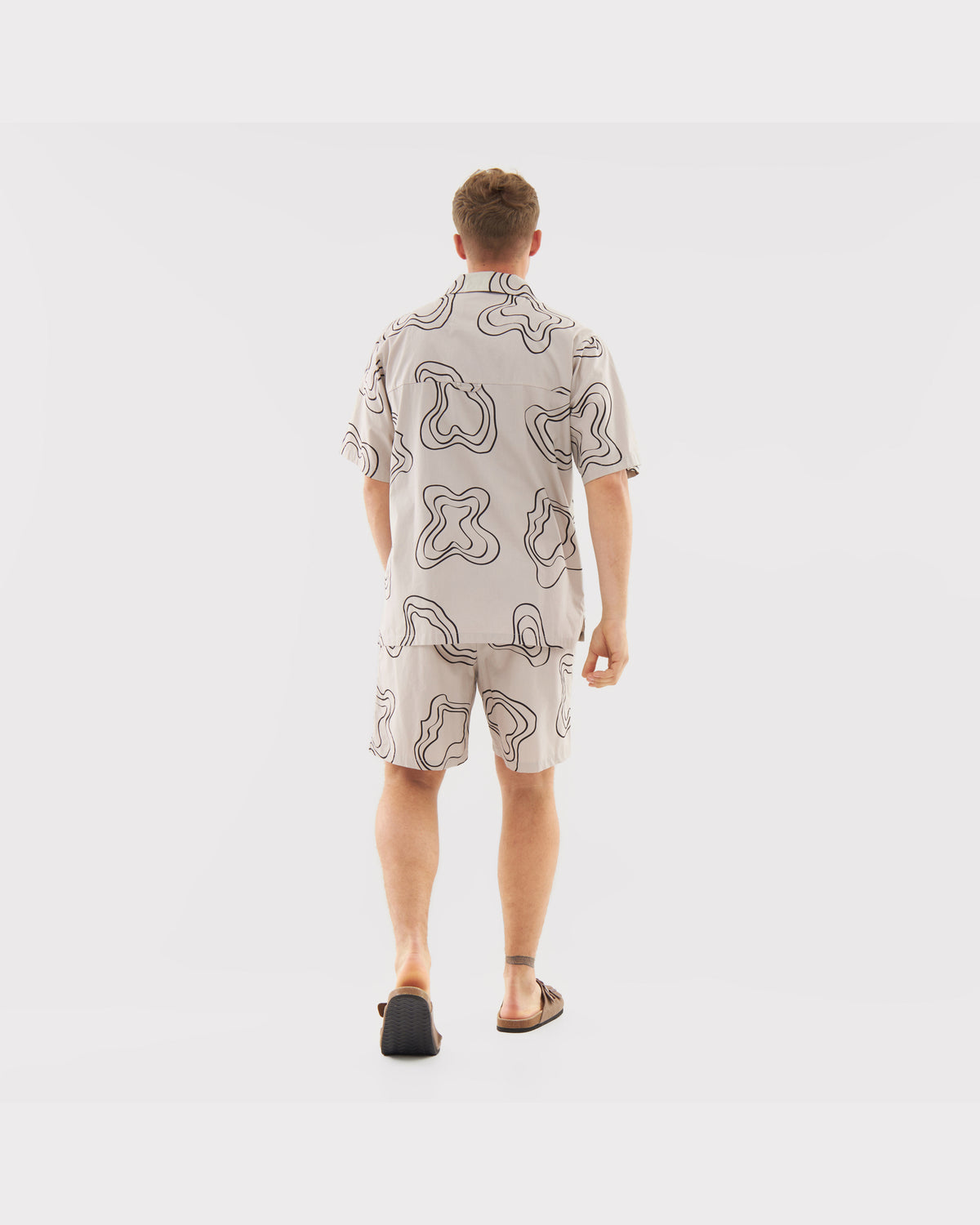 Männliches Modell von hinten mit lockerem Sommerhemd und Shorts mit abstraktem Muster aus dem Set 'Spencer'