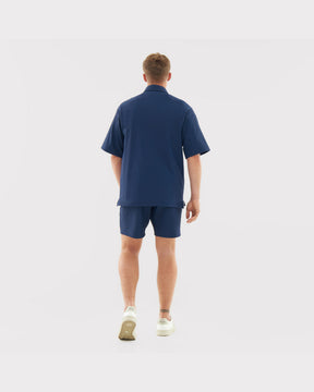 Mann trägt lockeres oversized Hemd und Shorts in Dunkelblau aus der 'Mason' Kollektion