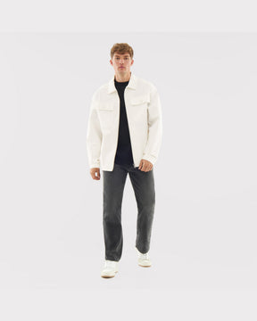 Mann trägt cremefarbene Overshirt 'Cameron' aus Baumwolle, kombiniert mit dunklen Jeans und weißen Schuhen