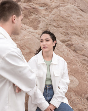 Zwei Personen in cremefarbenen Overshirts ‚Cameron‘ vor felsigem Hintergrund