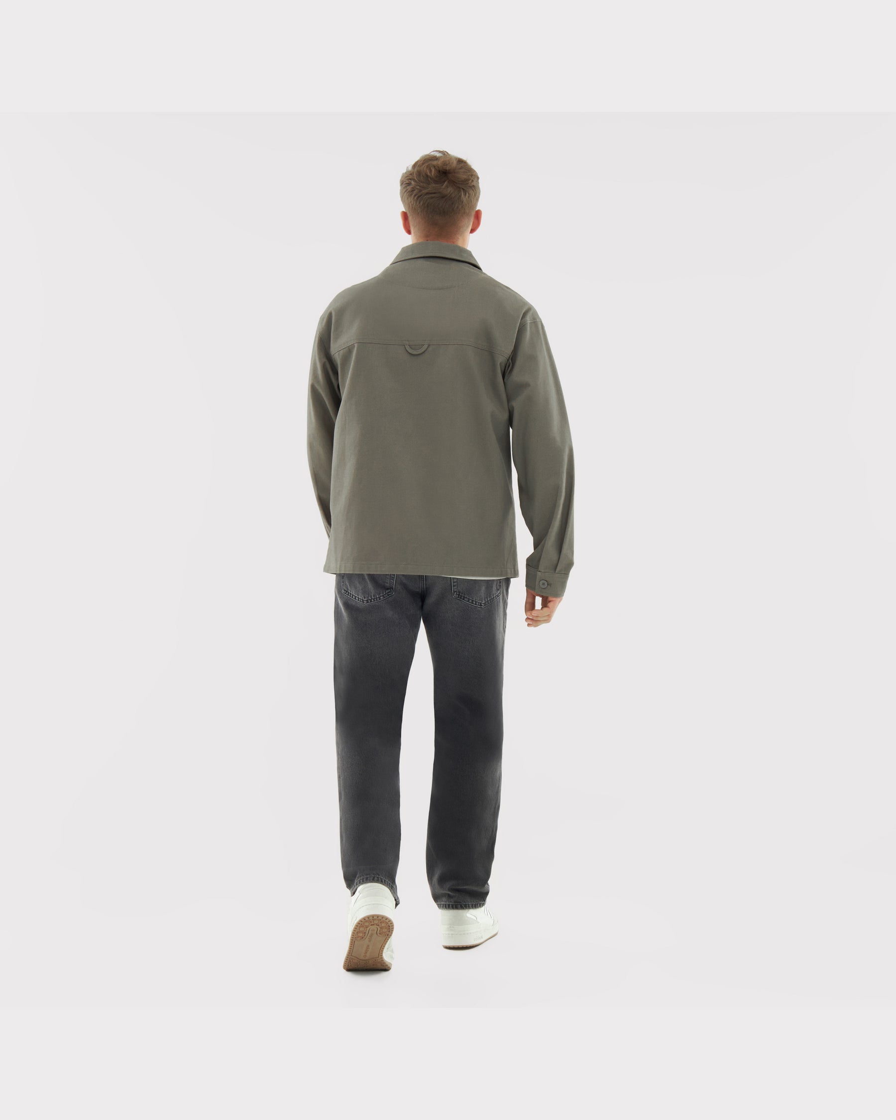 Rückansicht eines Mannes in olivgrüner Overshirt 'Cameron' und schwarzen Jeans