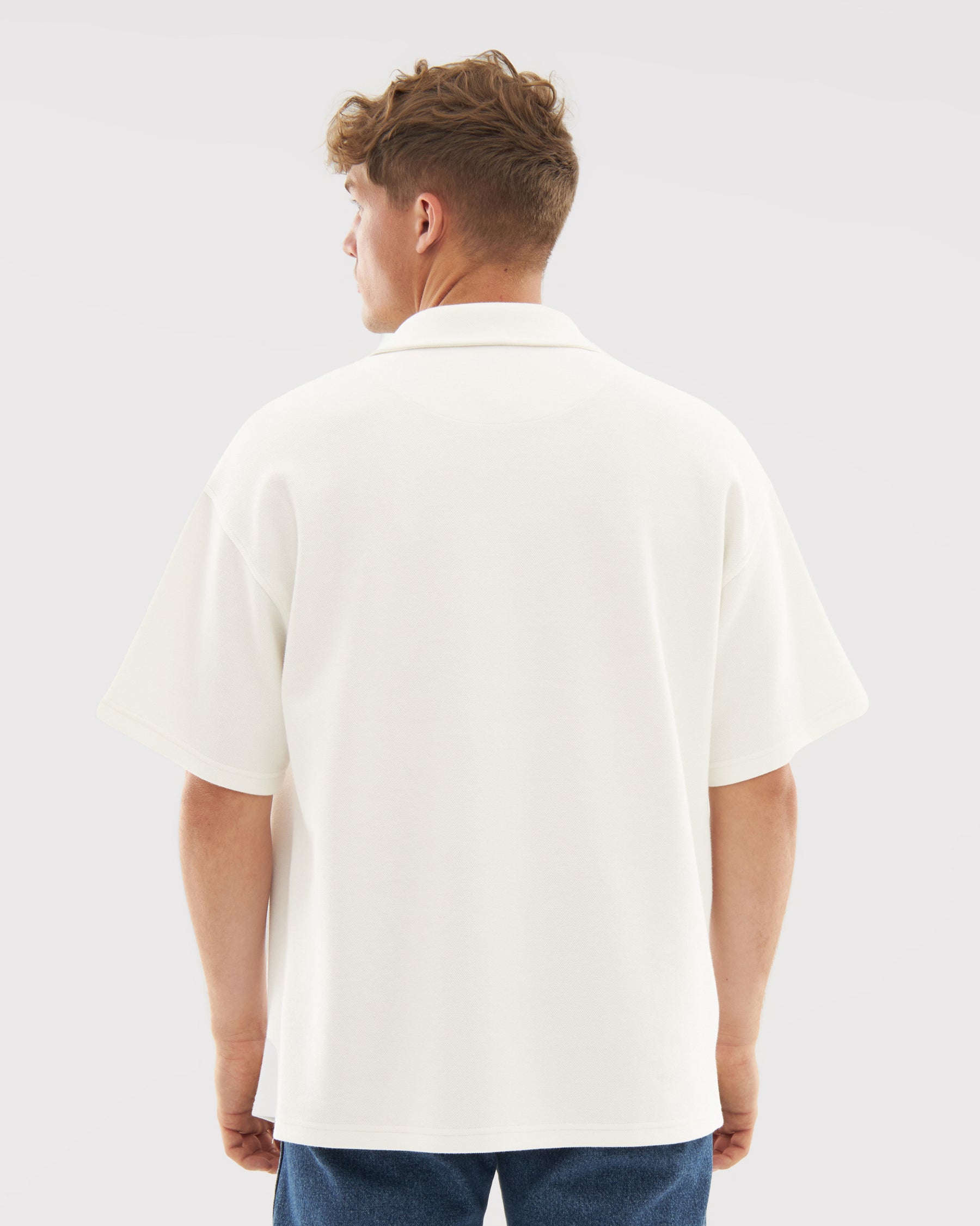 Mann trägt cremefarbenes Herren-Poloshirt mit kurzen Ärmeln, Rückenansicht