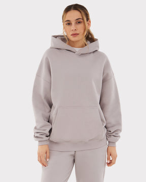 Übergroßer Hoodie 'Cody' in hellem Grau, getragen von Frau, mit Kapuze und Kängurutasche