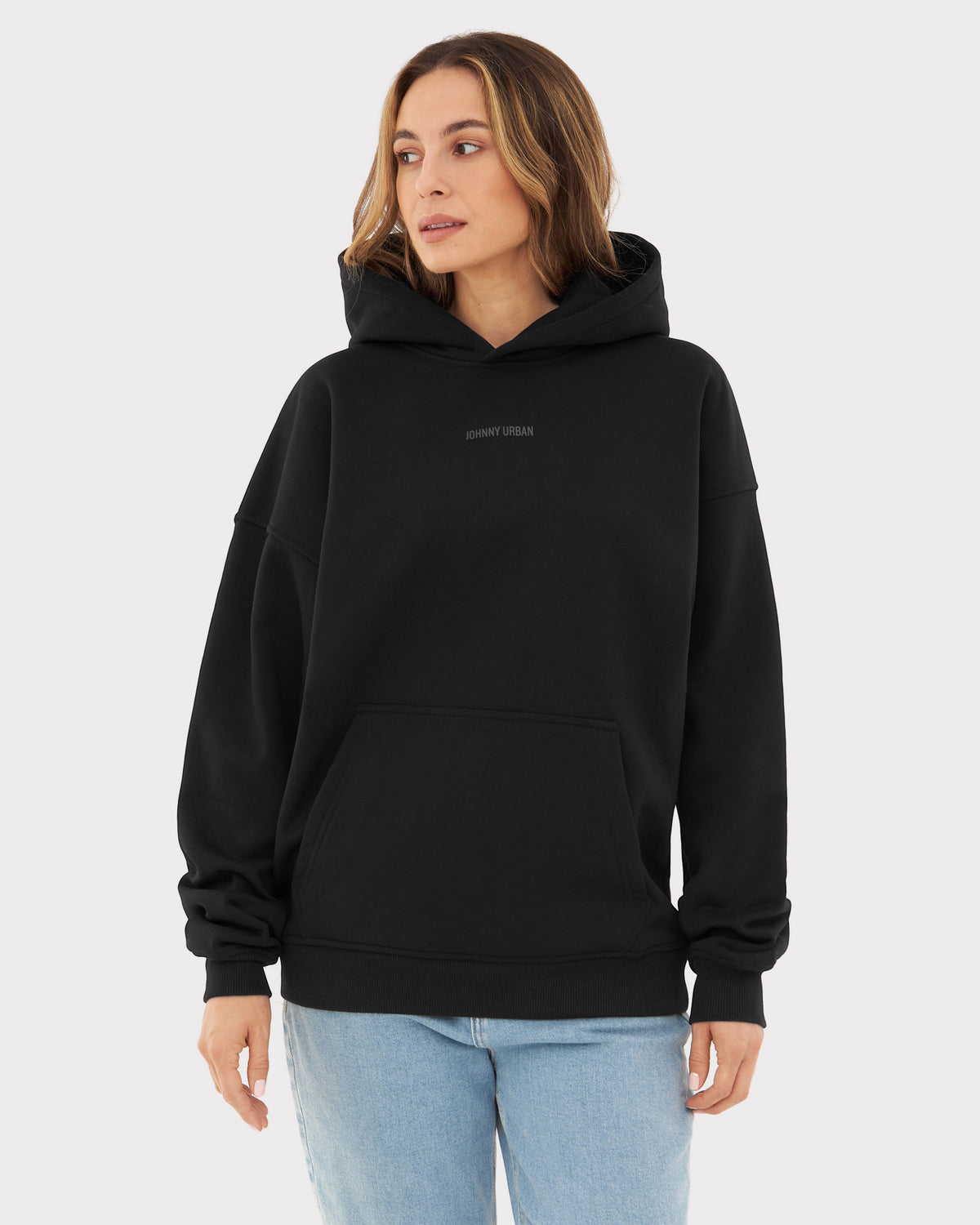Frau trägt schwarzen oversized Hoodie 'Cody' mit 'Johnny Urban' Print und Kängurutasche