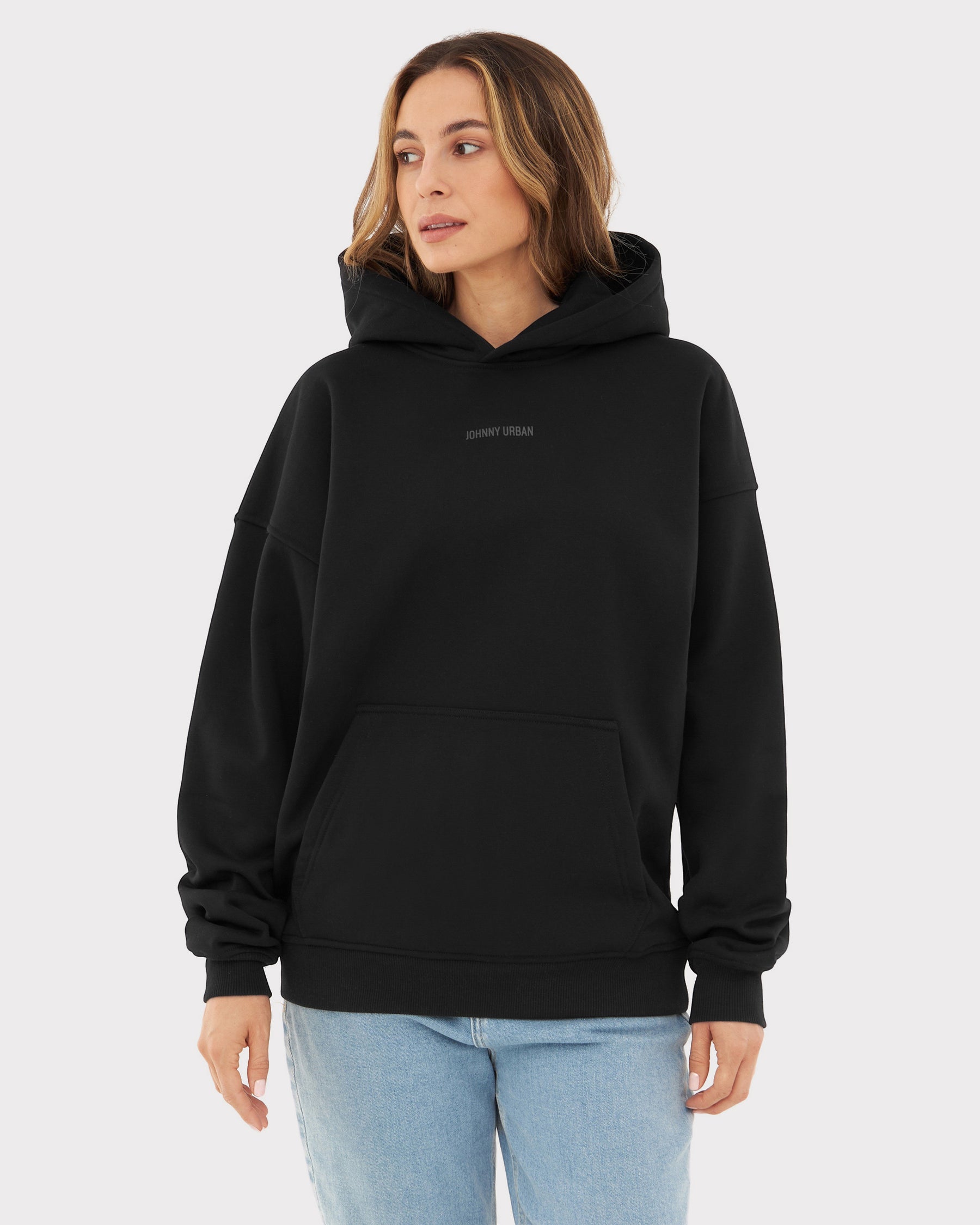 Frau trägt schwarzen oversized Hoodie 'Cody' mit 'Johnny Urban' Print und Kängurutasche