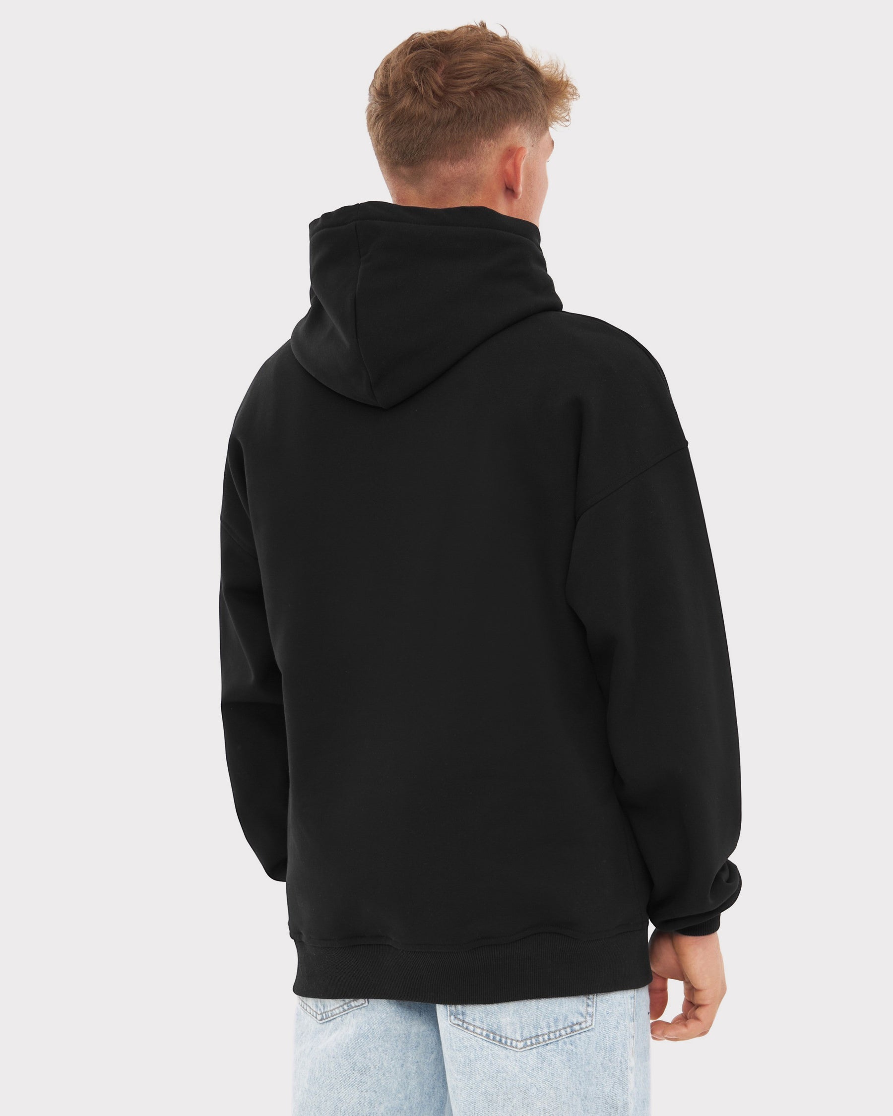 Mann trägt oversized schwarzen Hoodie 'Cody' Print von Johnny Urban, Rückansicht