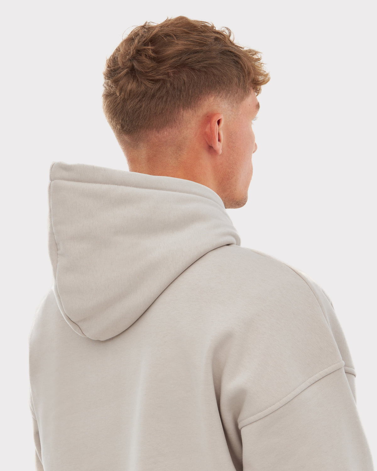 Mann von hinten mit oversized Hoodie ‚Cody‘ in Sandfarbe von Johnny Urban