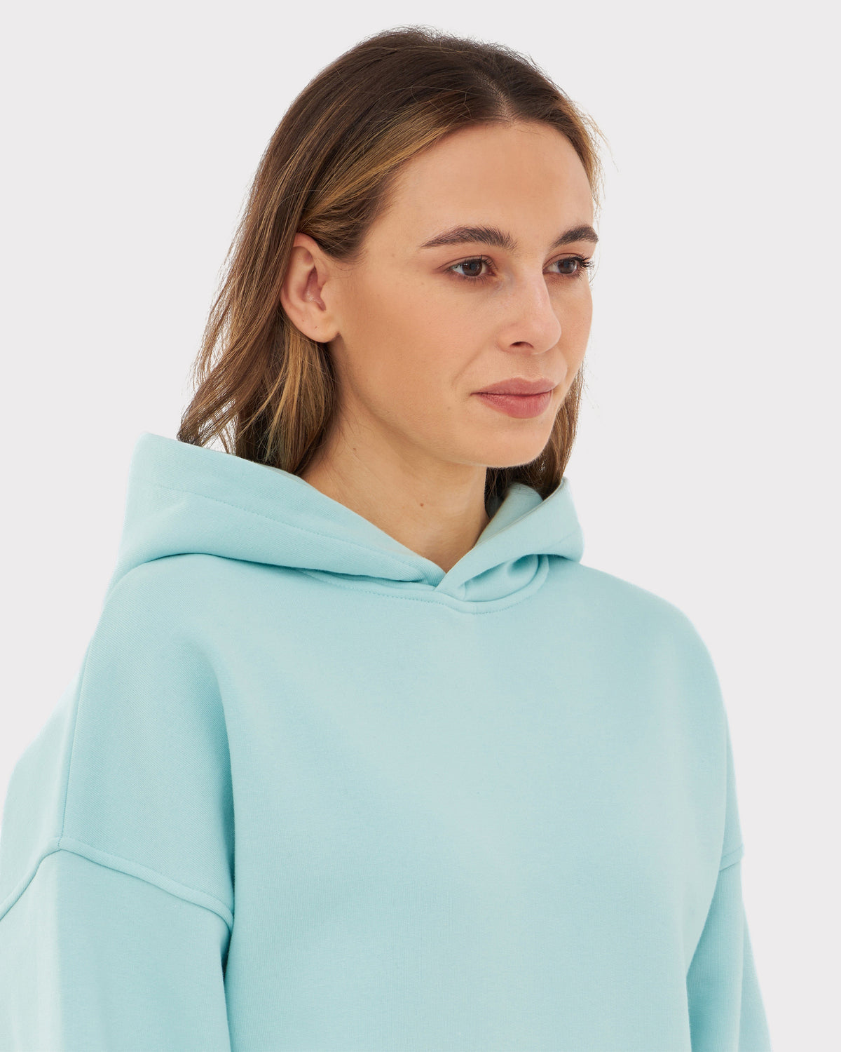 Frau trägt Oversized Hoodie 'Cody' in Hellblau mit Kapuze