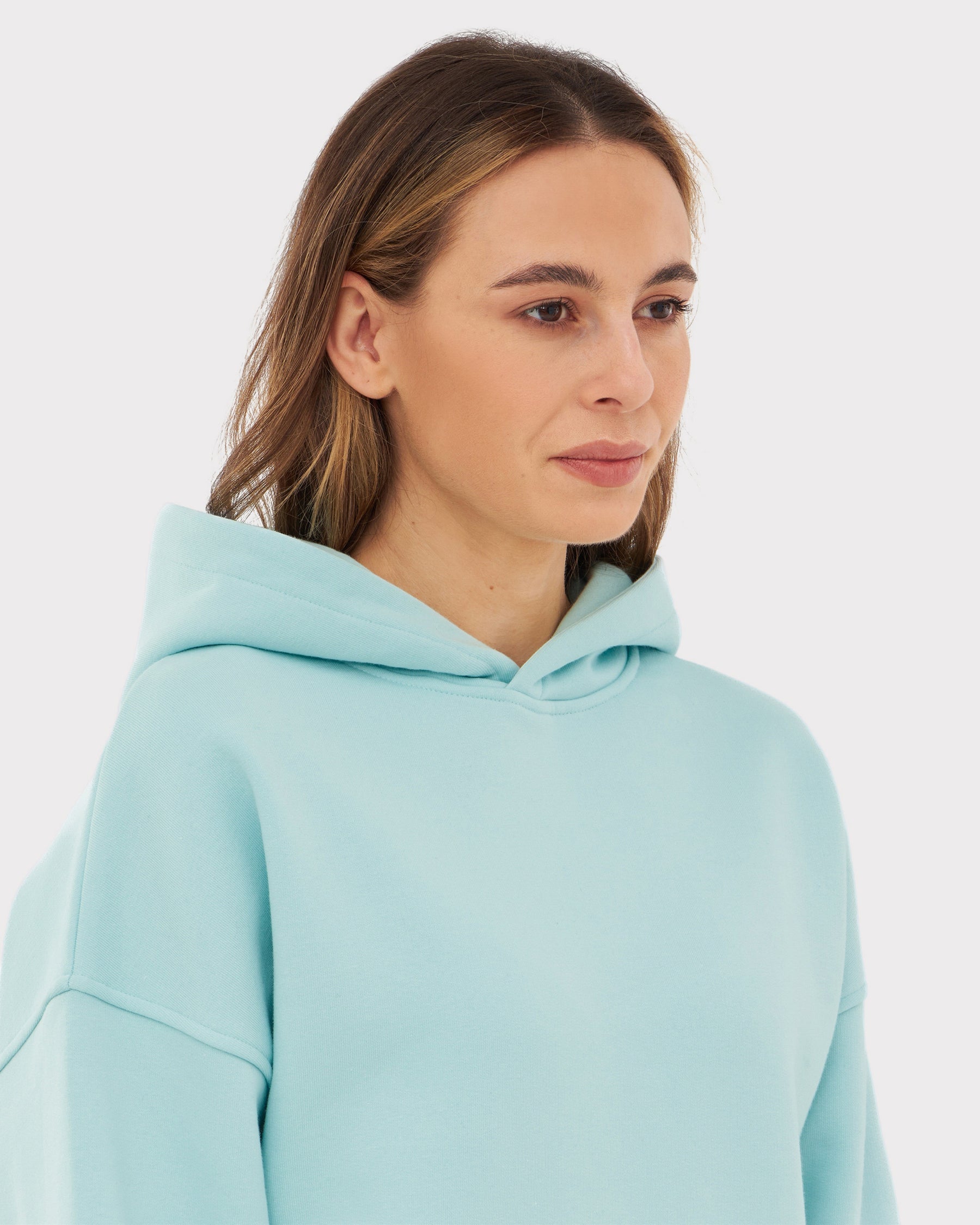 Frau trägt Oversized Hoodie 'Cody' in Hellblau mit Kapuze